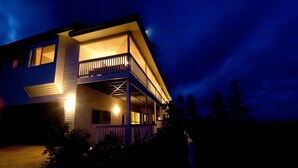 A two-story house with a balcony and a porch, surrounded by trees. - The White House (Norfolk Island)