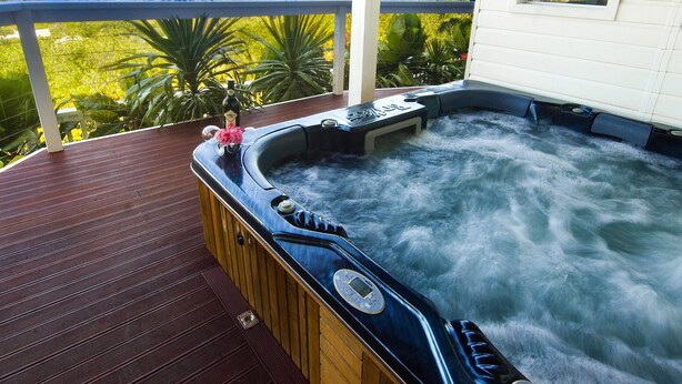 A hot tub on a wooden deck with a view of the ocean. - The White House (Norfolk Island)