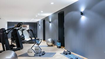 Un gimnasio moderno con máquinas de cardio, pesas y balones de ejercicio.