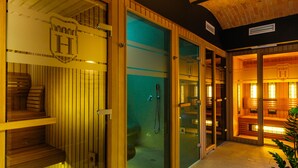Un sauna avec des bancs en bois, une porte en verre et un sol carrelé.