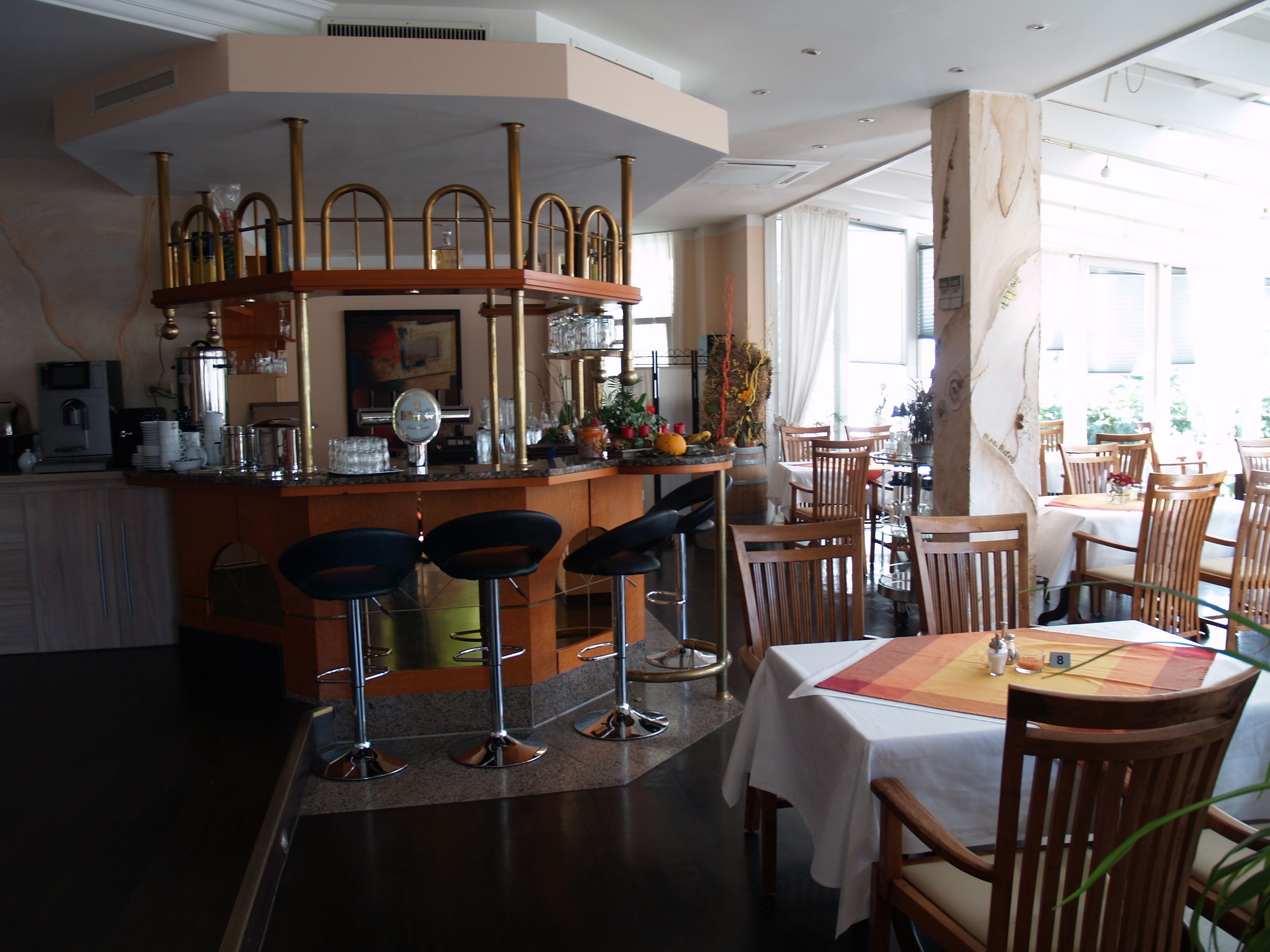 Un restaurant doté d’un bar, de chaises et de tables en bois.