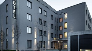 A modern hotel building with a flat facade, multiple windows, and a sign that reads "BOLD HOTEL". - Bold Hotel München Giesing (Munich)