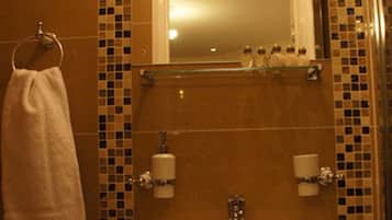 A bathroom with a sink, mirror, and tiled walls.