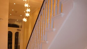 Un intérieur élégant, avec un escalier blanc et un lustre.