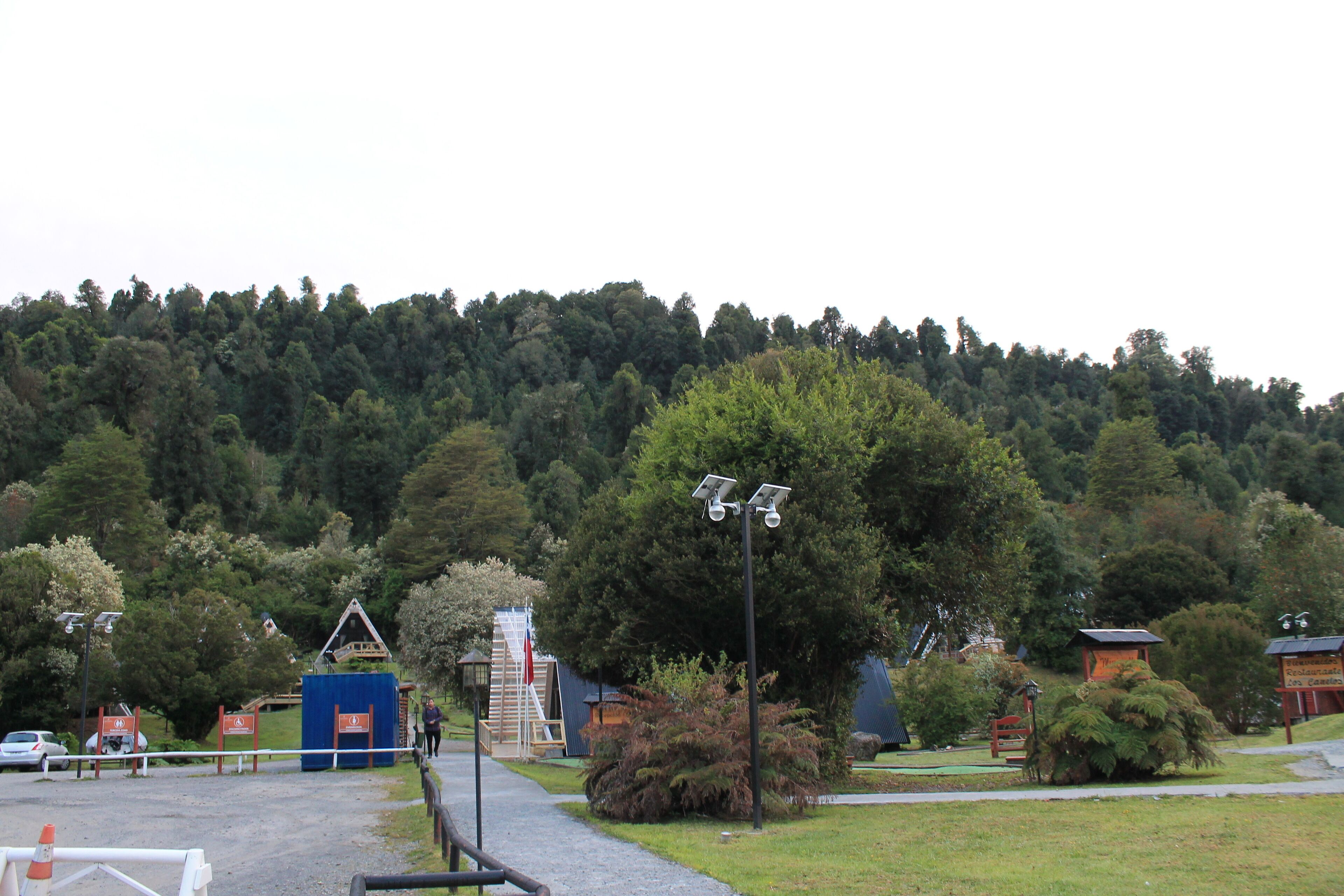 A pathway leading to a building with a small staircase and a blue structure.