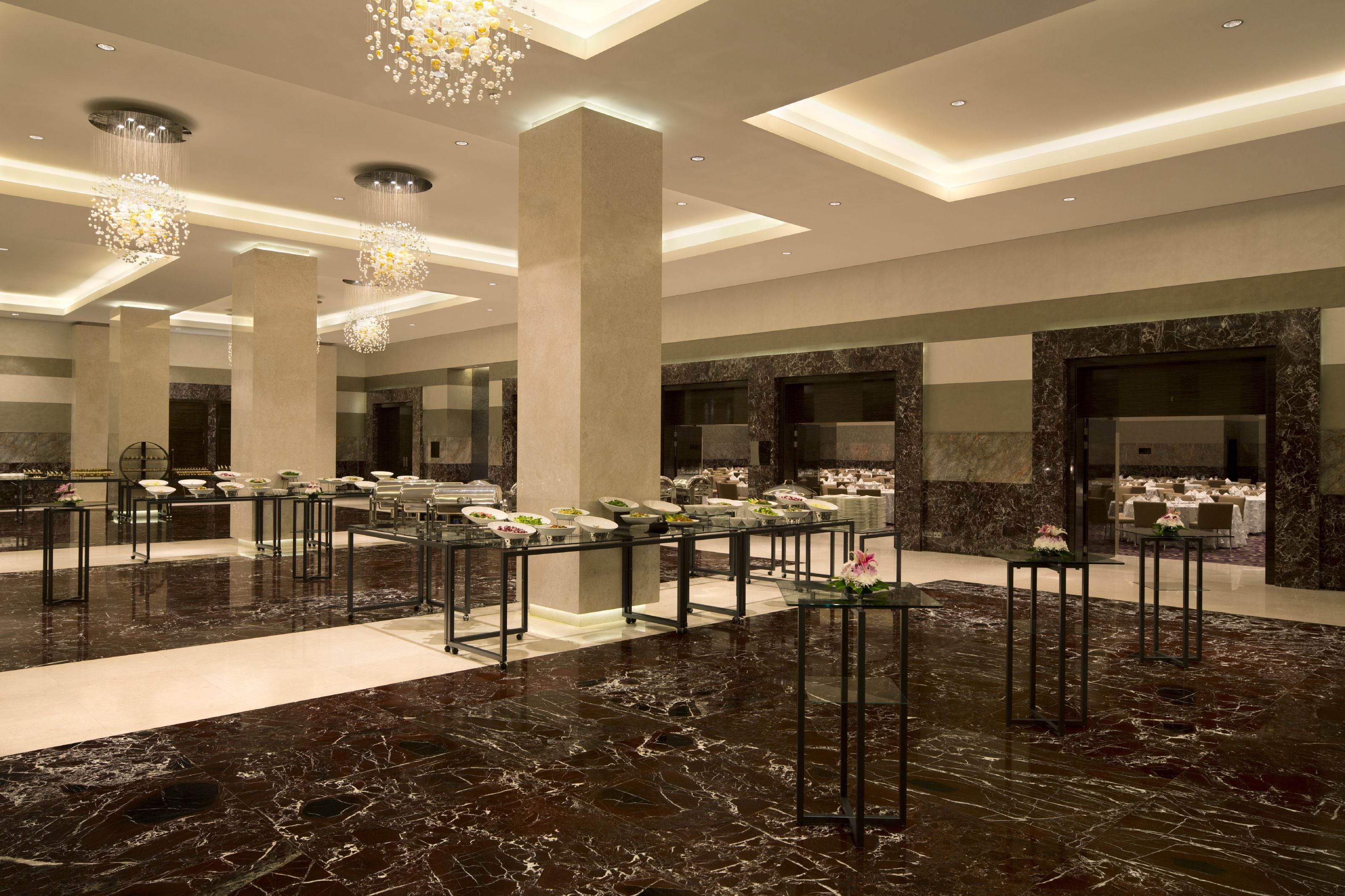 Eine großzügige Lobby mit Marmorböden, mehreren Sitzbereichen und einer zentralen Springbrunnen.