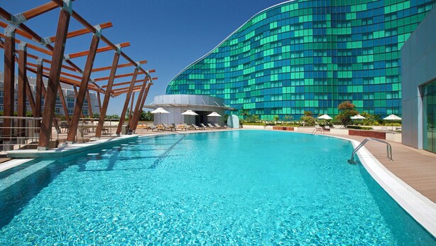 A swimming pool with a modern building in the background.