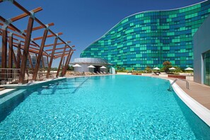A swimming pool with a modern building in the background. - Millennium Al Rawdah Hotel (Abu Dhabi)