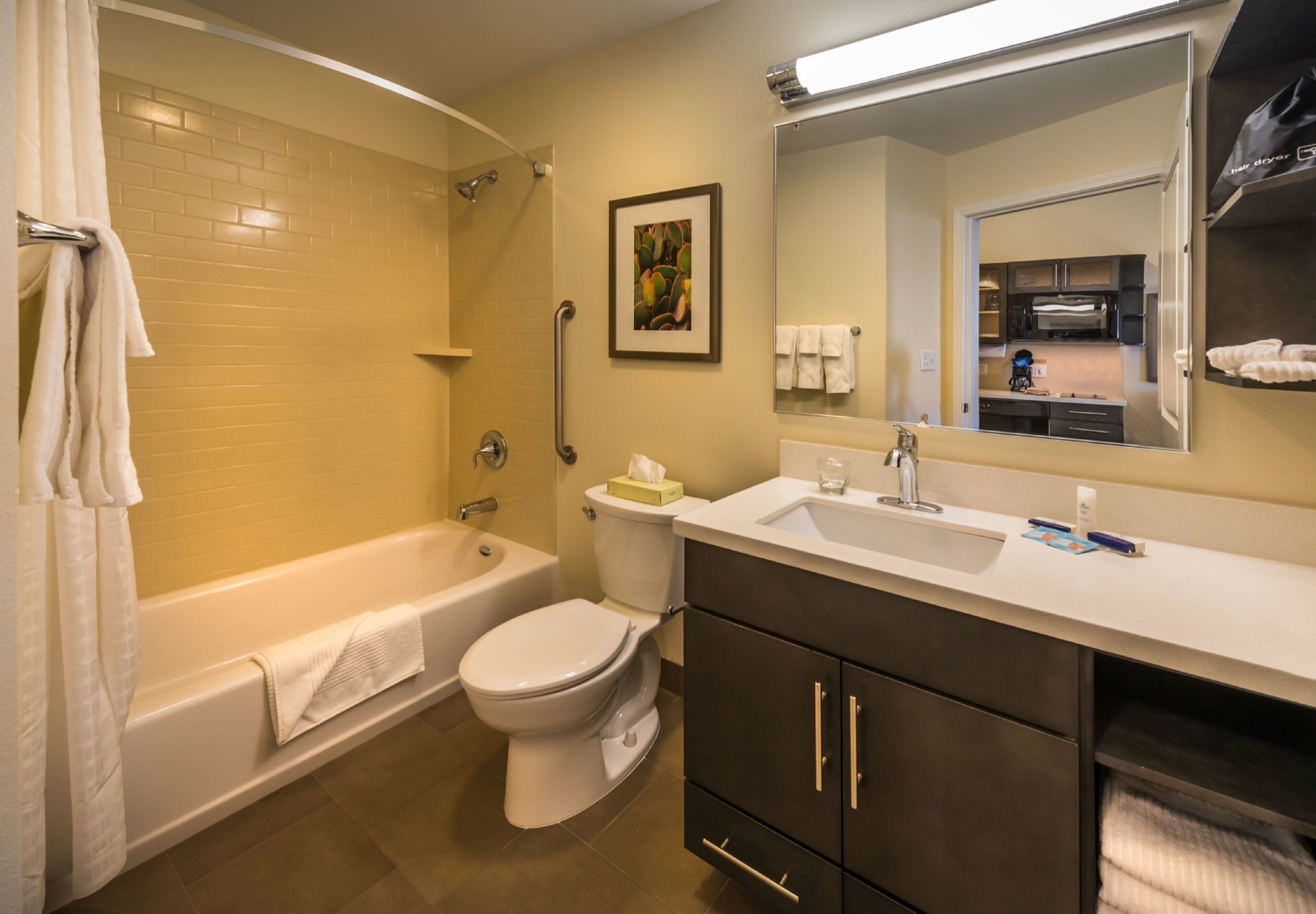 A bathroom with a bathtub, toilet, sink, and a mirror.