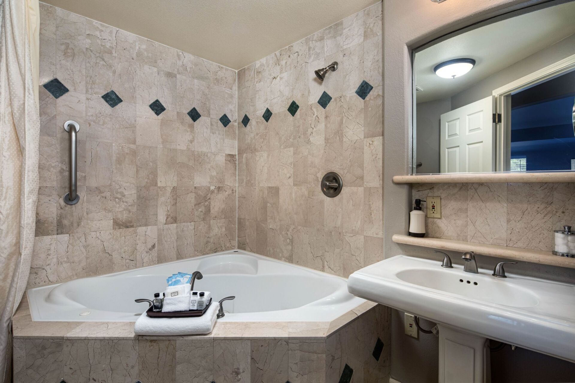 Un baño con bañera, lavabo y espejo.