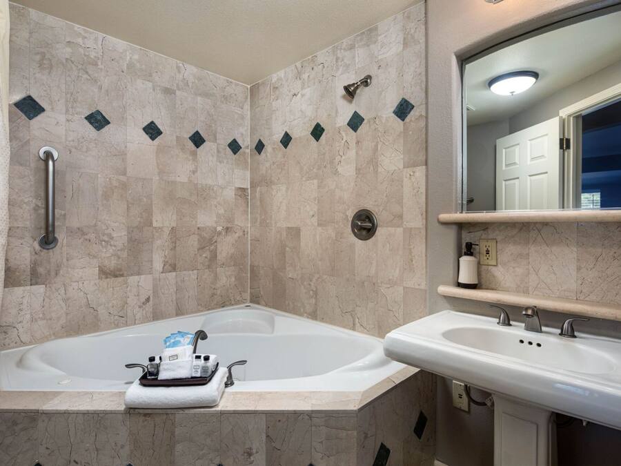 Un baño con bañera, lavabo y espejo.