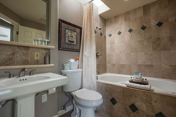 A bathroom with a toilet, sink, and bathtub.