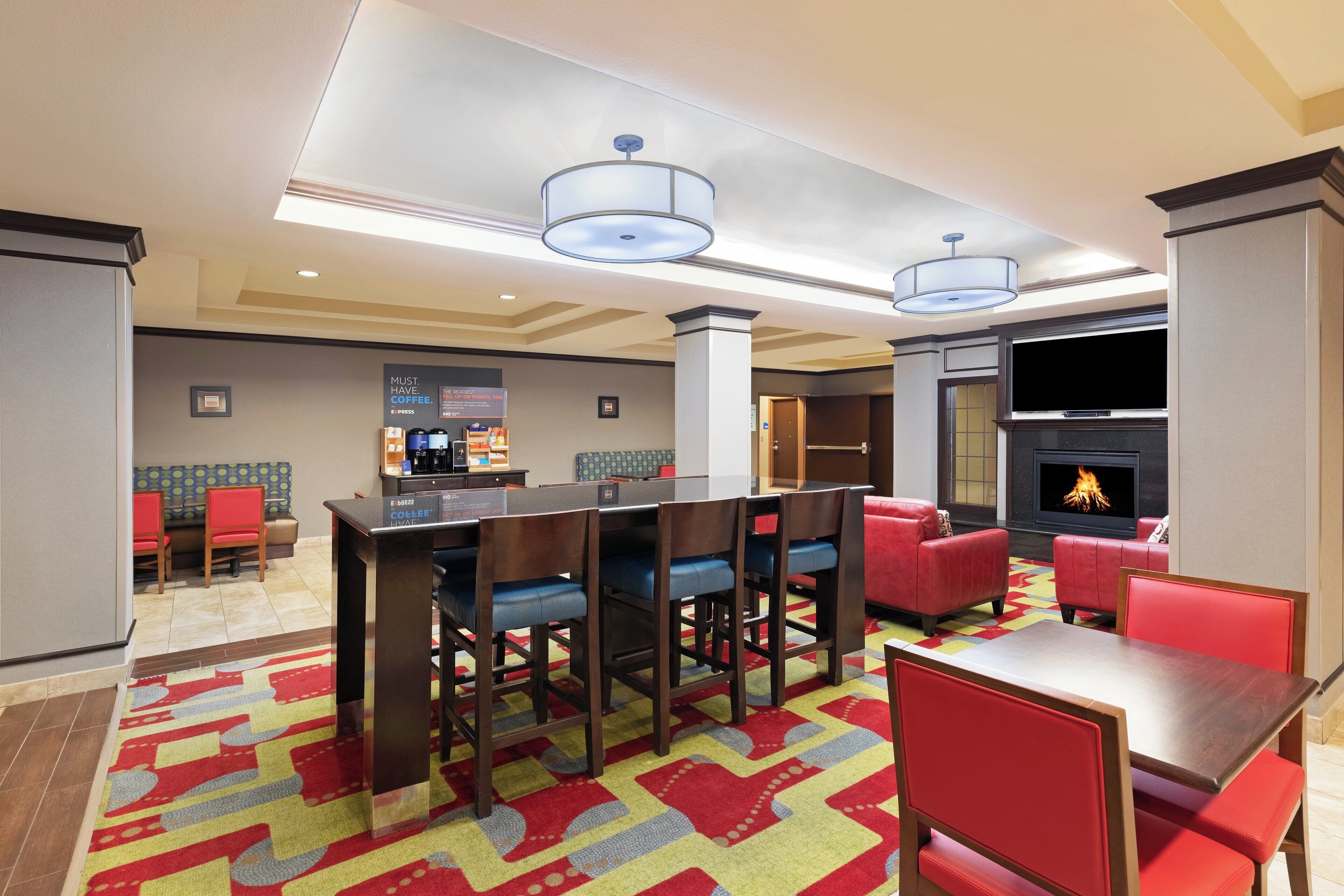 A hotel lobby with a bar area, seating, and a fireplace.