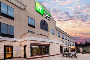 A hotel with a large sign for Holiday Inn Express & Suites, featuring a stone facade and multiple windows. - Holiday Inn Express & Suites Floresville by IHG (Floresville)
