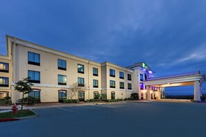 Un hôtel doté d’un grand parking, d’une entrée couverte et d’un panneau indiquant un temps d’attente de 15 minutes.