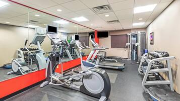Ein Fitnessstudio mit Laufbändern, Crosstrainern und Krafttrainingsgeräten.
