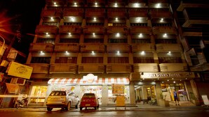 Un hôtel à plusieurs étages, reconnaissable à son enseigne bien visible indiquant « Asia Stars Hotel ».