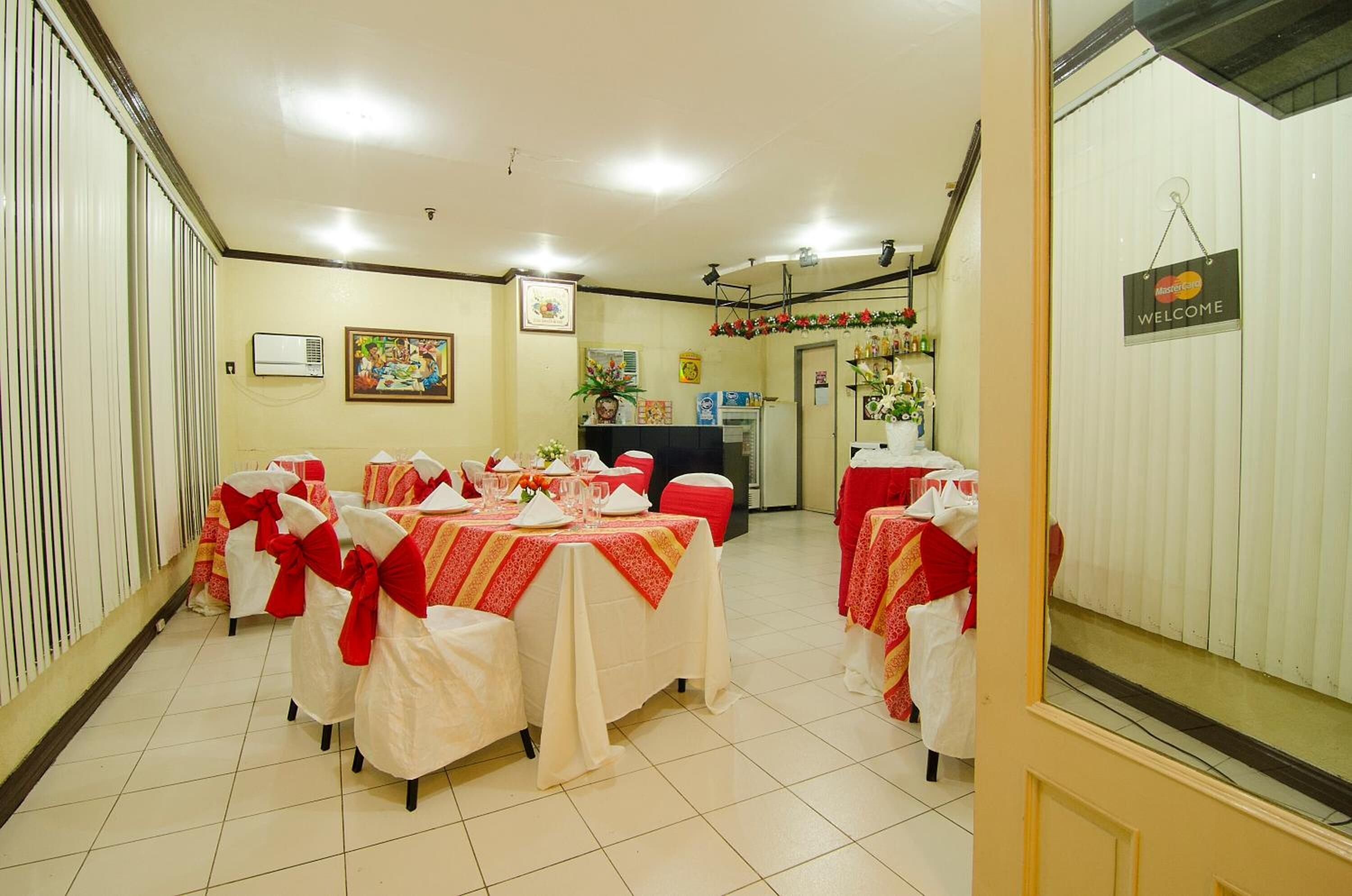 A dining area with tables set for a meal, a reception desk, and a 'Welcome' sign.