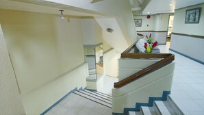 Un escalier avec une rampe en bois et des murs blancs.