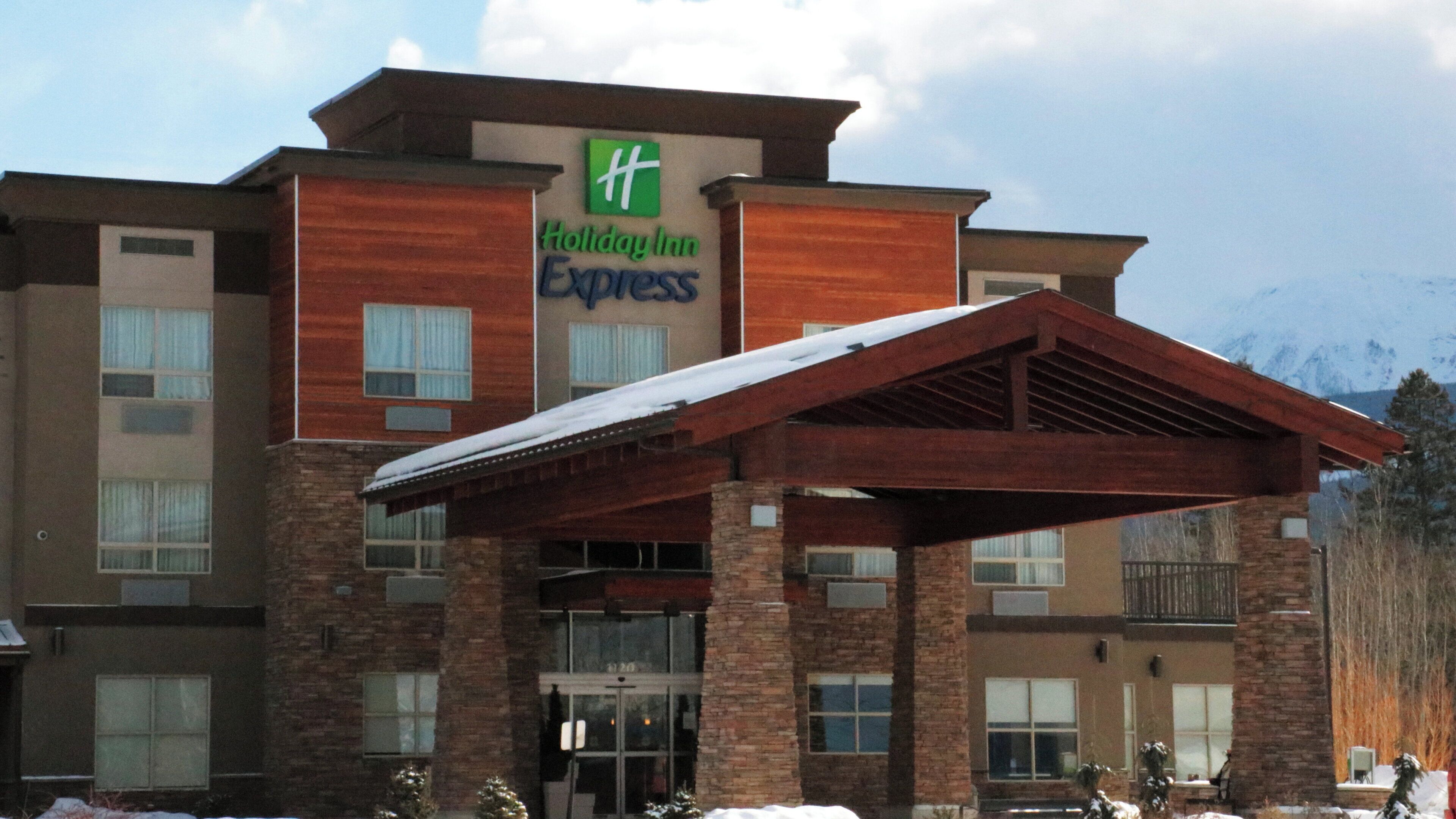 A Holiday Inn Express building with a brick facade, large windows, and a covered entrance.