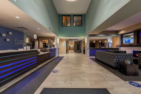 A hotel lobby with a reception desk, seating area, and a hallway leading to other rooms. - Holiday Inn Express Golden-Kicking Horse by IHG (Golden)