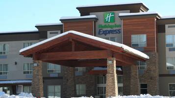 A Holiday Inn Express building with a covered entrance and snow on the roof.