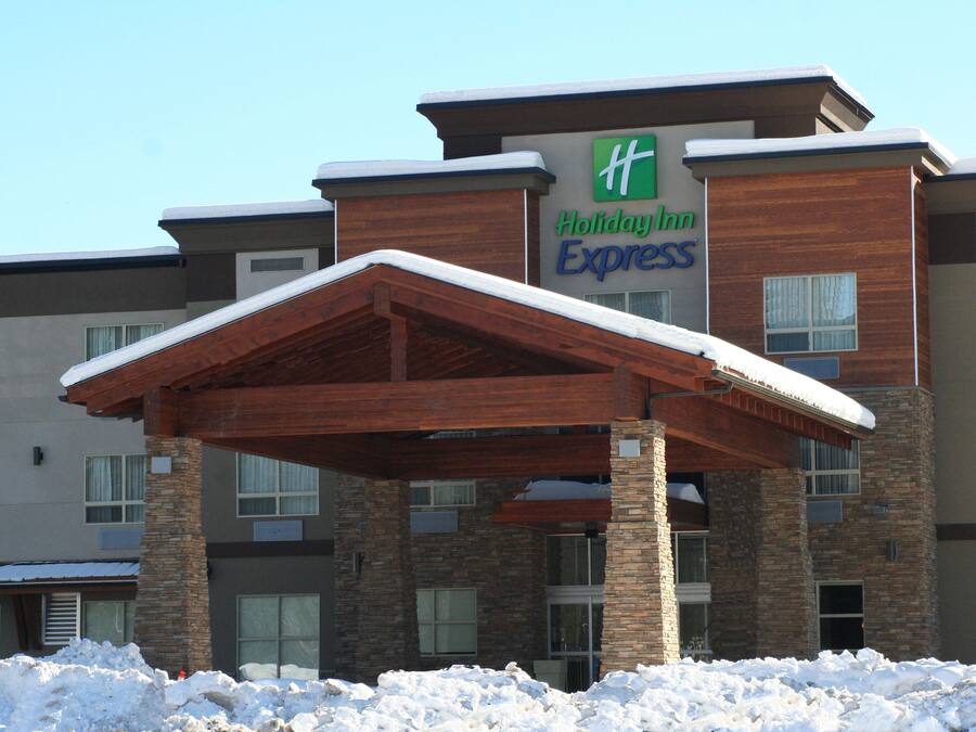 A Holiday Inn Express building with a covered entrance and snow on the roof.