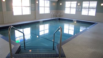An indoor swimming pool with clear water, tiled walls, and windows allowing natural light.