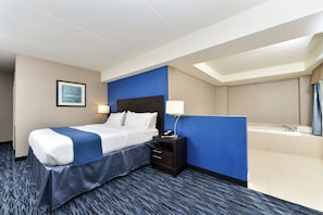 A hotel room with a bed, bedside tables, a desk, a lamp, a painting, and a bathroom with a bathtub and sink.