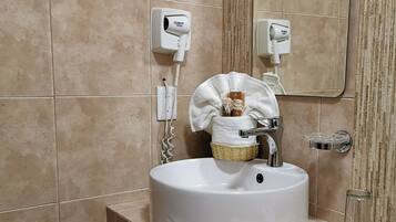 Suite junior, 2 camas matrimoniales | Baño | Regadera, amenidades de baño gratuitas, secadora de cabello, toallas