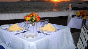 A table set for two with a view of the sunset over the sea. - Hotel Acapulco Malibu (Acapulco)