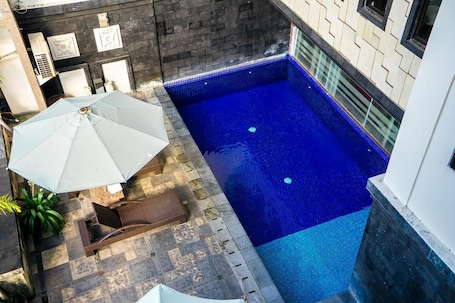 Outdoor pool, open 9:00 AM to 10:00 PM, pool umbrellas, pool loungers. Hotel Puri Ayu