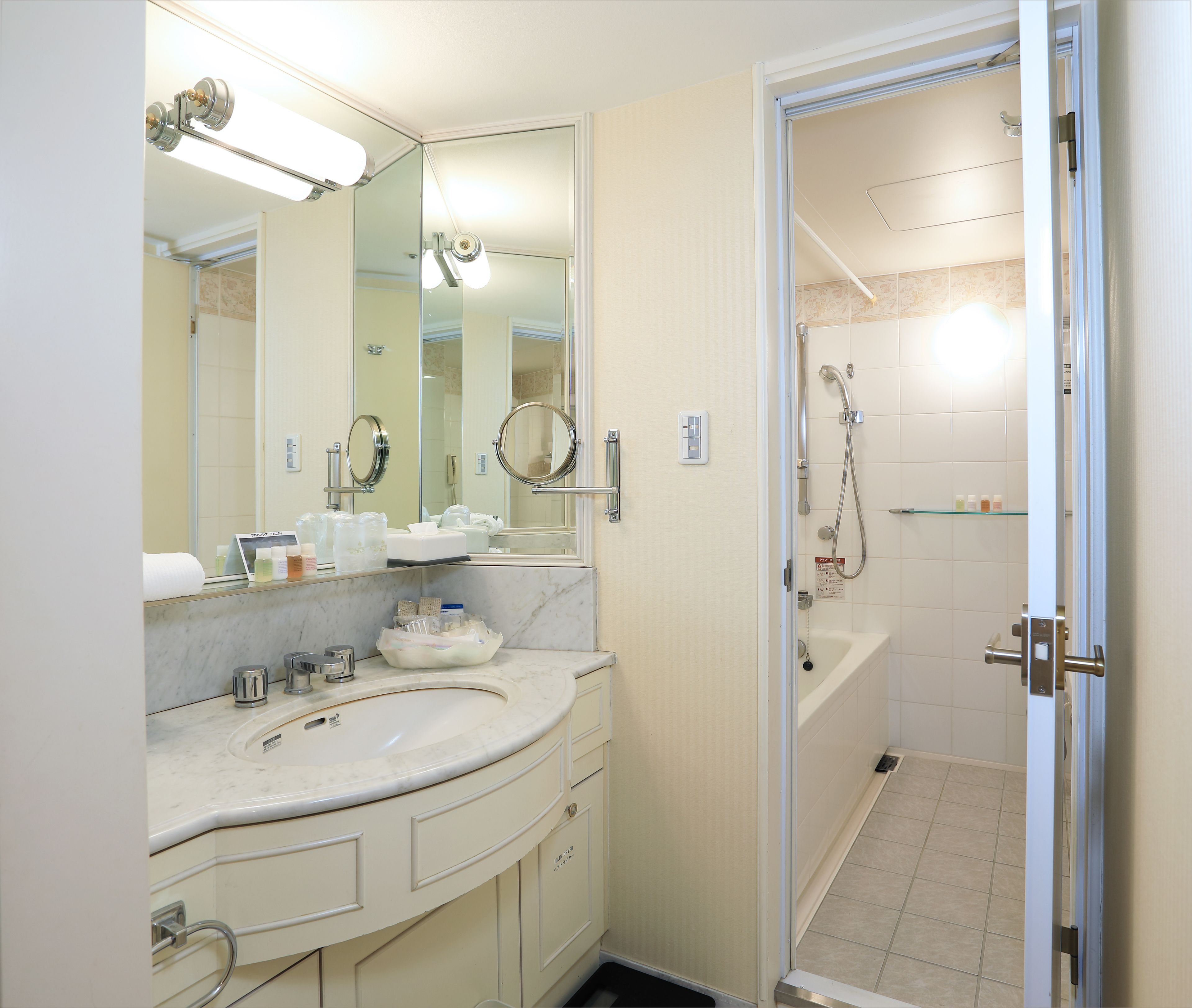 Un baño con lavamanos, espejo y ducha.