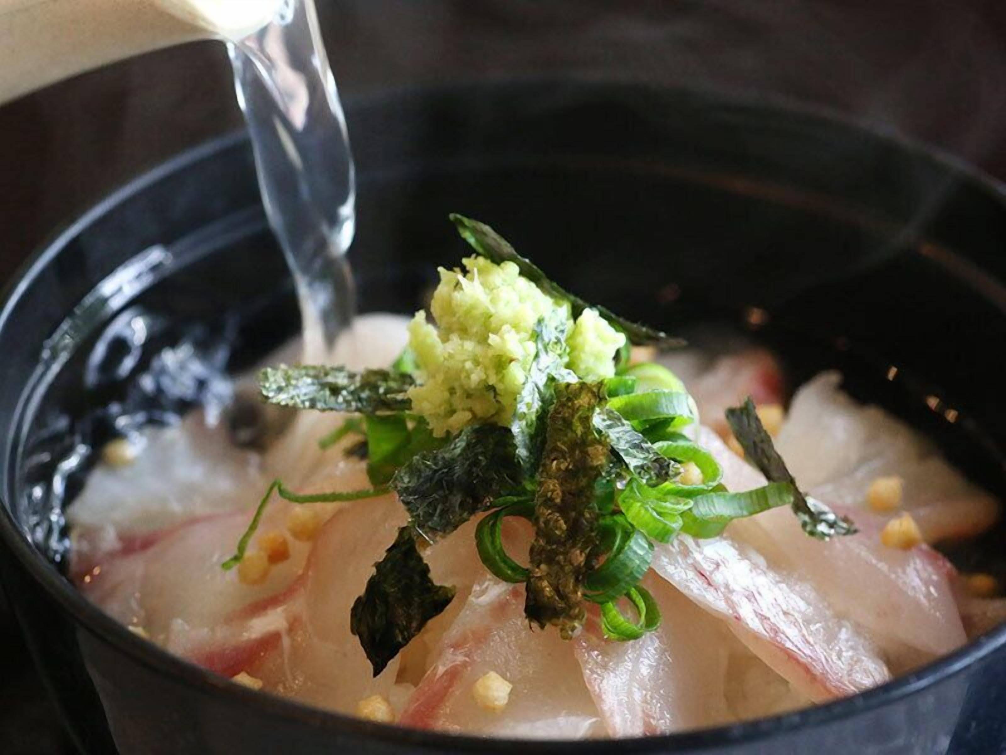 Een kom met sashimi en garneringen.