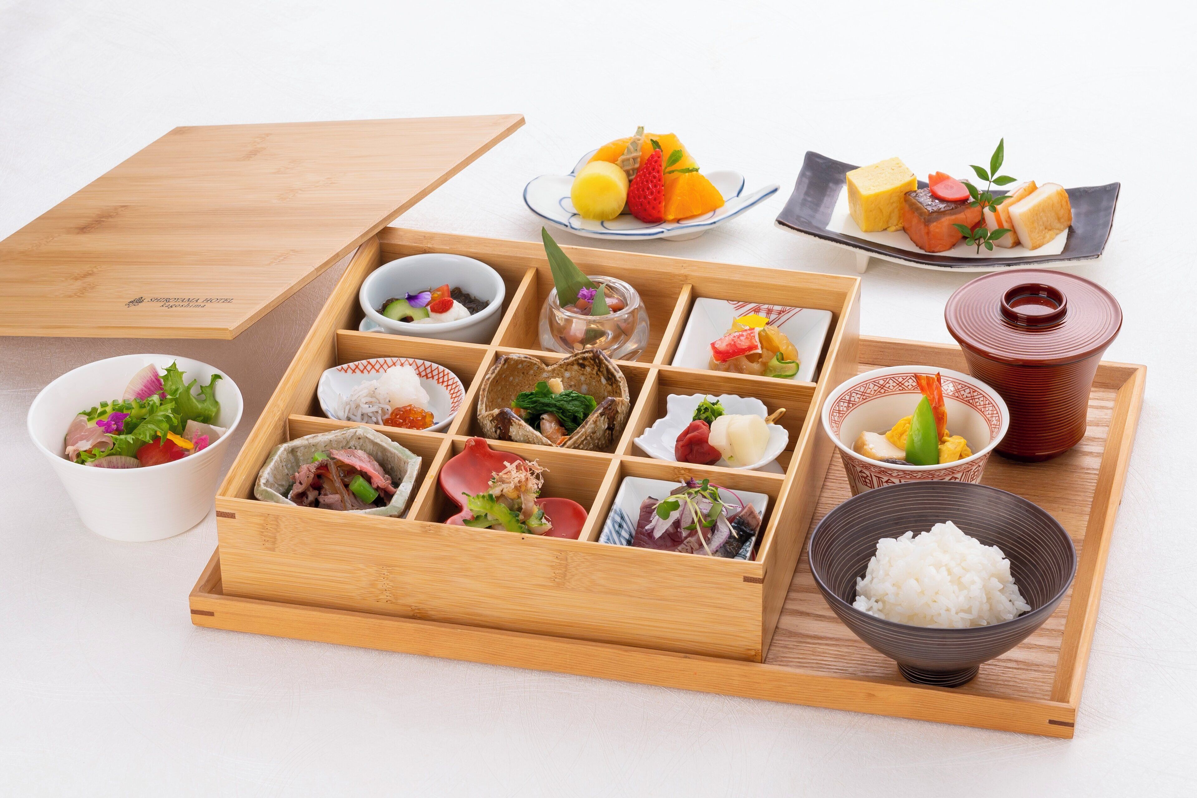 A traditional Japanese meal setup with various dishes and a wooden tray.
