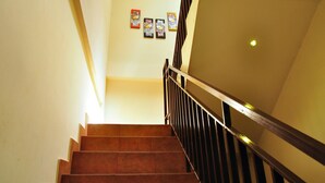 A staircase with wooden steps and a metal railing, leading upwards. - Kuta Sari House (Kuta)