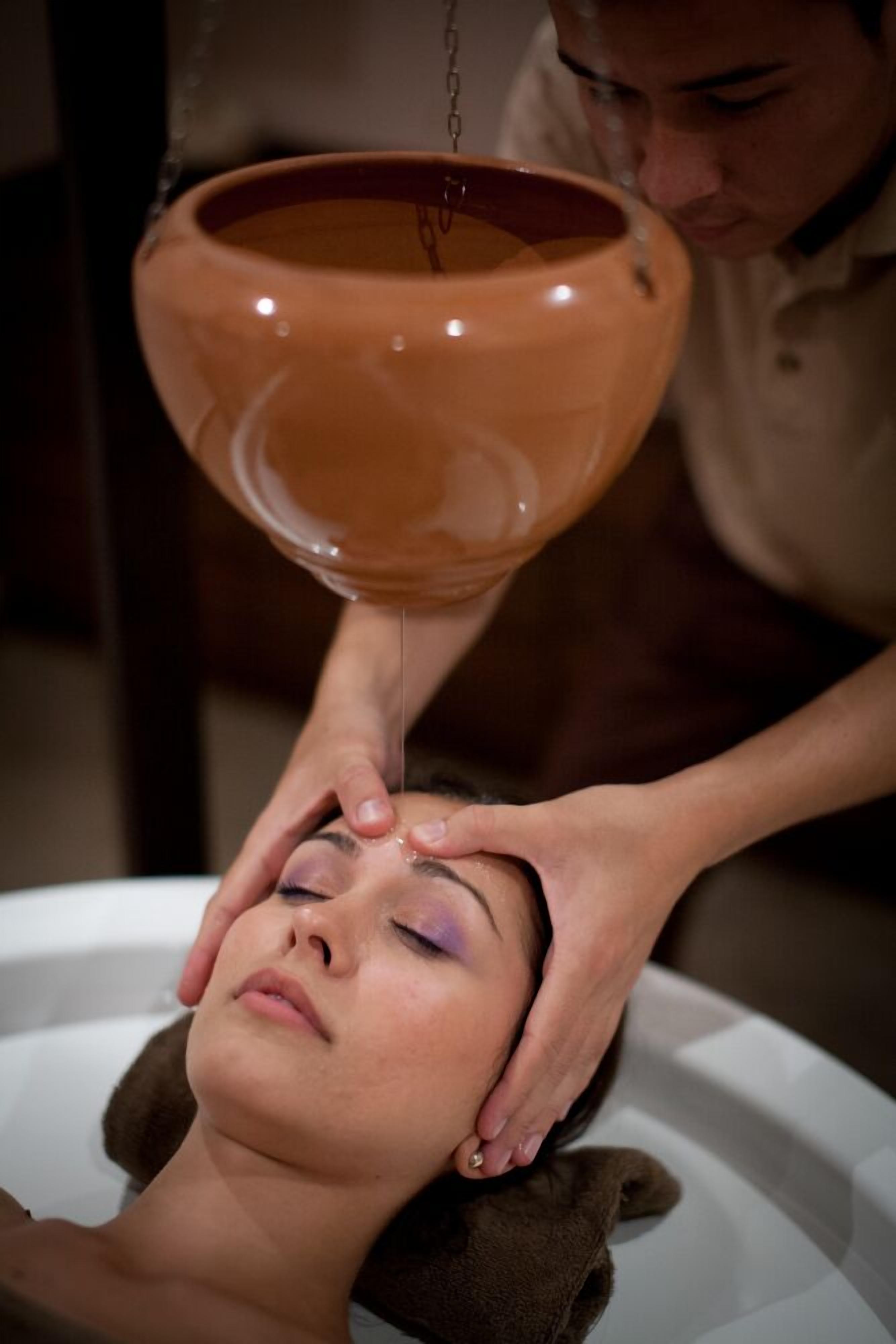 Una persona recibiendo un tratamiento facial con un cuenco de cerámica.