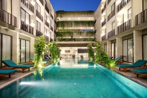 Una piscina al aire libre, sillones reclinables de piscina