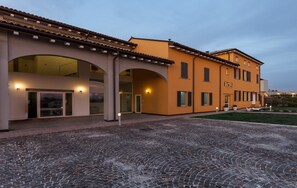 A building with a courtyard, large glass doors, and a sign reading "f52". - Hotel Forlanini52 Parma (Parma)
