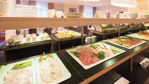Un buffet proposant une variété de plats, notamment des viandes, des salades et des desserts.