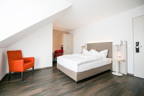 A modern hotel room with a large bed, a red armchair, a bedside table with a lamp, and a view of the hallway. - Best Western Hotel Airport Düsseldorf - Ratingen (Ratingen)