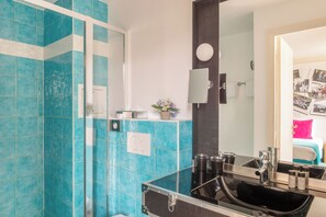 A bathroom with blue tiles, a black sink, and a mirror. - Hôtel Le 123 Sébastopol - Astotel (Paris)