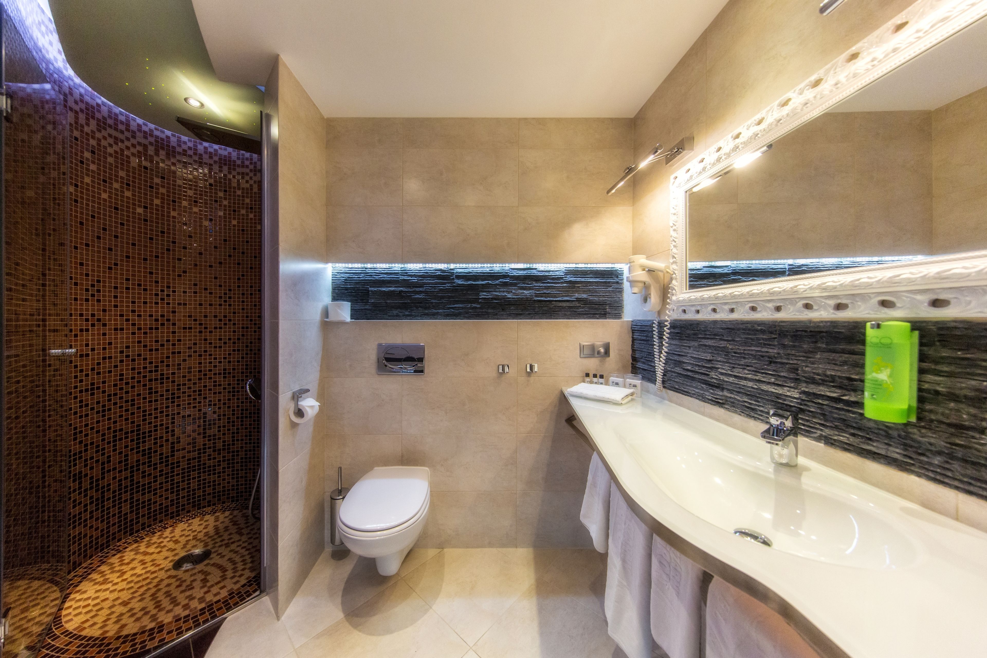 A modern bathroom with a shower, toilet, and sink.
