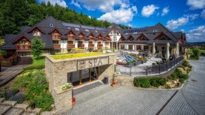 Un complejo turístico de spa con varias edificaciones de estilo chalet, un jardín en la azotea y zonas de estar al aire libre.