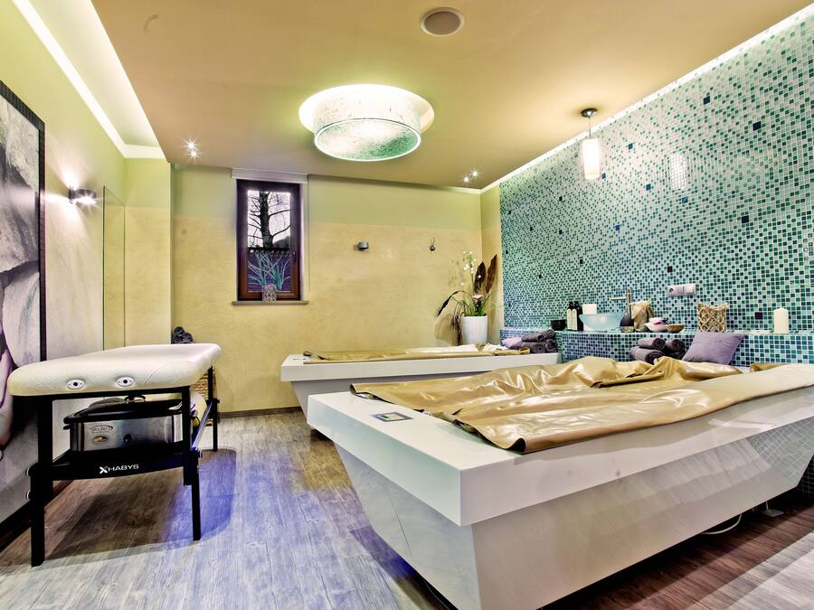 Une salle de bain moderne avec un grand miroir, une baignoire et un meuble-lavabo avec des articles de toilette.