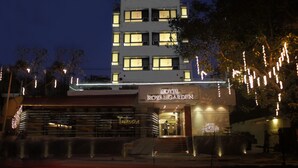 Ein Hotel mit dem Namen „Royal Garden“ mit modernem Design, das einen markanten Eingang und beleuchtete Beschilderung aufweist.