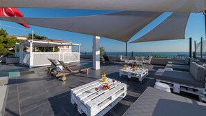 A rooftop terrace with outdoor seating, a pool, and a view of the sea. - Rumours Inn (Istanbul)