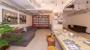 A modern living room with a sofa, a wooden coffee table, and a bookshelf. - Rumours Inn (Istanbul)
