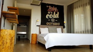 A modern hotel room with a bed, bedside lamps, a wall-mounted sign, and a wooden floor. - Rumours Inn (Istanbul)