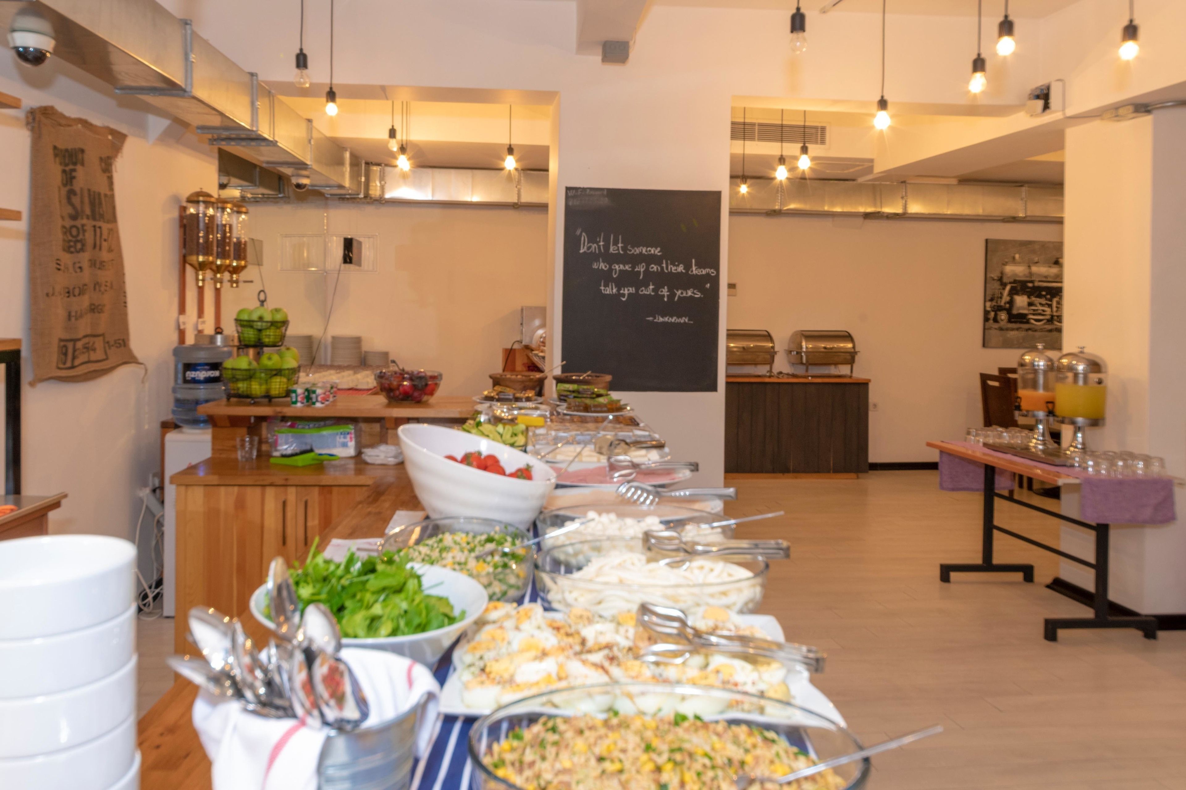 Una mesa de buffet con diversos alimentos y utensilios.